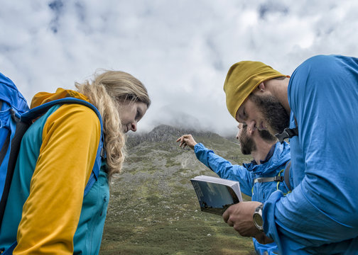 UK, Lake District, Great Langdale, three hikers with tour guide at Pike of Stickle