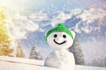 Funny snowman against Swiss Alps