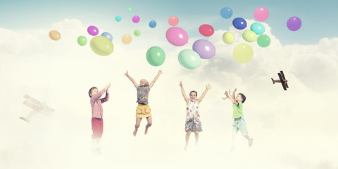 Playful children catch balloons