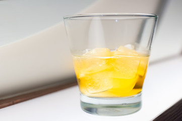 Glass with whisky and ice on the table in the club