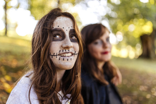 Portrait of masquerade girl at Halloween with her friend in the background
