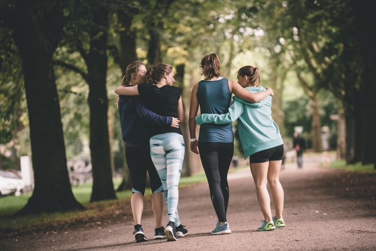 Four female joggers in park