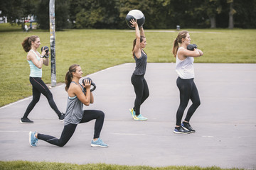 Four women having an outdoor boot camp workout