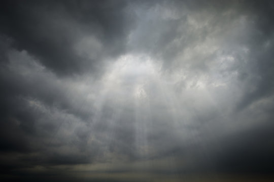 Dark Clouds rain storm and sun beam in storm. Dramatic sky background