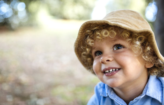 Portrait of smiling blond little boy wearing hat