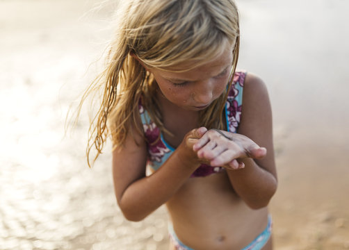 Little girl on the beach with an lever on her hand