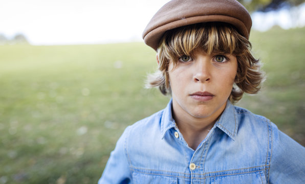 Portrait of serious looking blond boy wearing flat cap