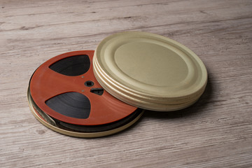 Old motion picture film reel with golden can