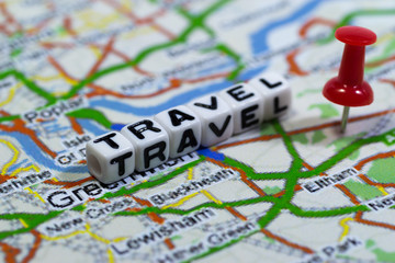 White blocks with the text, TRAVEL, with red pin on map