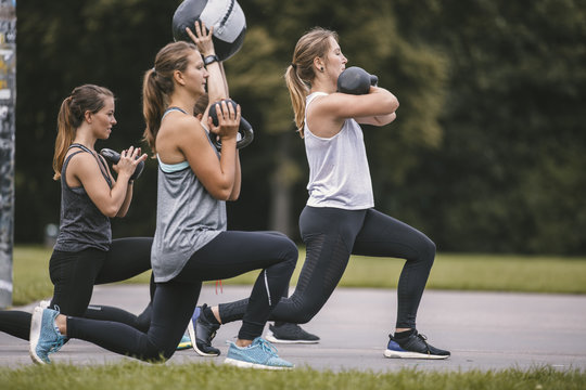 Four women having an outdoor boot camp workout