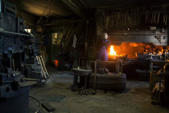 Germany, Bavaria, Josefsthal, senior blacksmith at work in historic blacksmith's shop