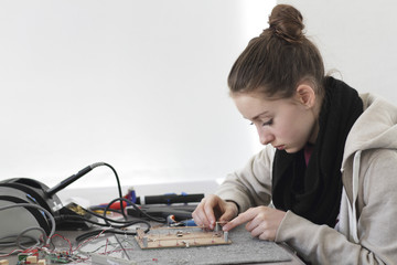 Young woman working on optical sensor in an electronic workshop