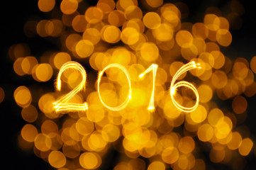 Happy new year 2016 writing sparkles firework with orange defocu