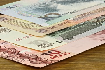 Banknoten der BRIC Staaten auf Holzhintergrund