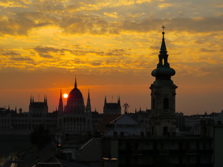 Fototapeta na wymiar Siluettes of Parliament Building and roofs of Budapest at sunset, Hungary