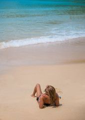 Fototapeta na wymiar Beautiful young woman portrait laying on the tropical beach.