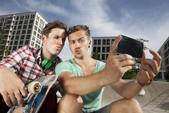 Germany, Bavaria, Munich, Two friends with smartphone taking self-portrait