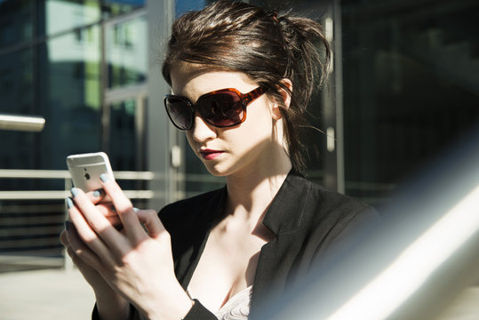 Portrait of young business woman using smartphone