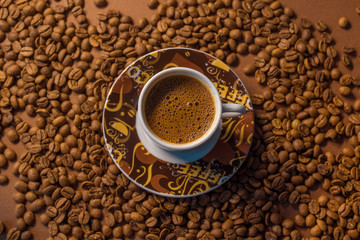 Coffee cup with beans on wooden background