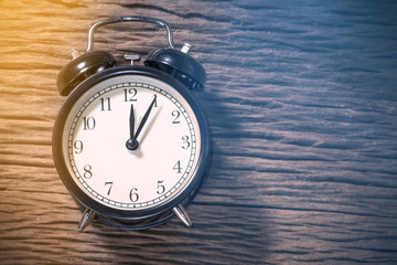 Retro alarm clock on a wood table. Photo in retro color image st