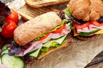 Grilled Sandwich with lettuce, slices of fresh tomatoes, cucumber, red onion, salami, ham and cheese.