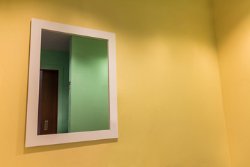 Big mirror on yellow wall