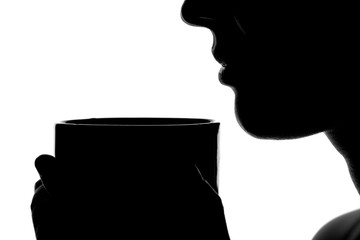 silhouette of a woman with a cup in hands