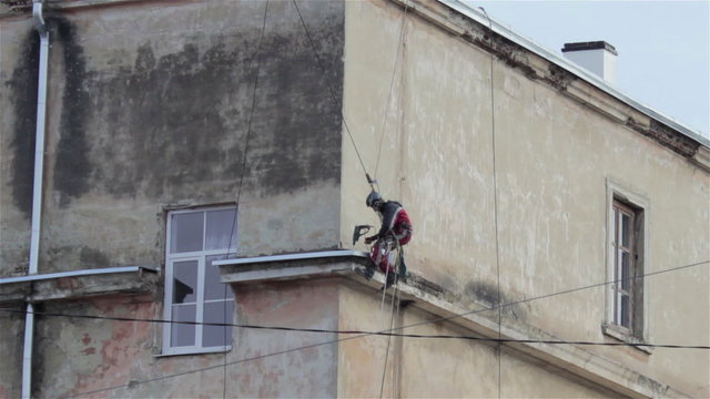 Man climbs the wall/on the wall man climbing to make pulling electricity cable