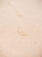 Fototapeta na wymiar Close up of footprints on the beach sand at the sunset