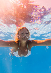 Obraz na płótnie Canvas Young woman swimming underwater