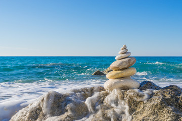 Stones pyramid on sand symbolizing zen, harmony, balance. Ocean
