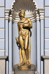 Statue of a greece ancient male god, part of an ornate colonial buildingl