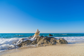 Stones pyramid on sand symbolizing zen, harmony, balance. Ocean