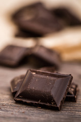 Dark Chocolate Bars on Crumbled Paper and Wooden Table