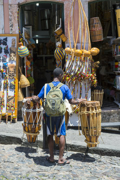 Brazilian street performer walks with rustic pair of drums in the Pelourinho historical district of Salvador, Bahia, Brazil