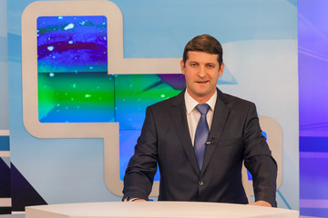 Male anchorman in tv studio. Live broadcasting
