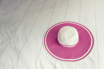 Pink beach hat on bed