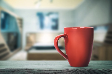 Red cup with hot drink on the table (vintage toning)