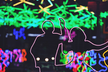 Night illumination with a dancing couples in Moscow