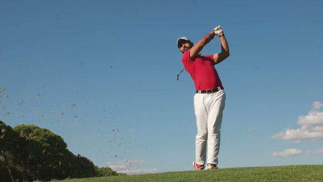 young healthy golfer hitting golf shot with club on course