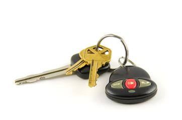 Car and house keys with key chain alarm transmitter with a red alarm button on a white background