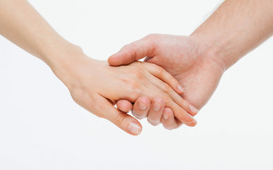 Man's hand gently holding woman's hand