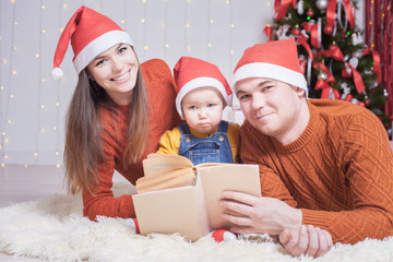 Fototapeta na wymiar Happy family reading a book with christmas fairy tale