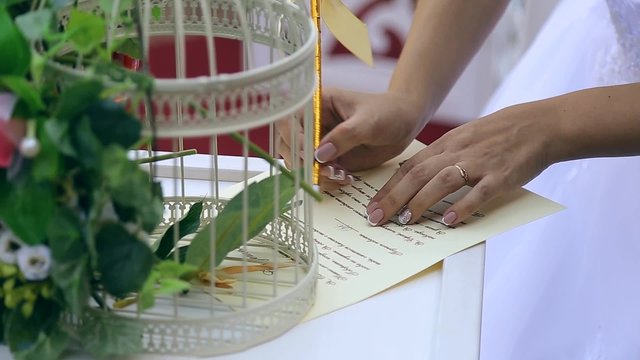 bride and groom put signatures on wedding ceremony