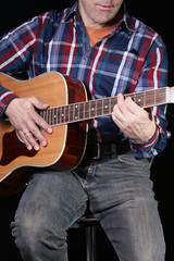 Obraz premium Musiker spielt Konzertgitarre, schwarzer Hintergrund