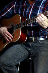 Obraz premium Musiker spielt Gitarre, dunkler Hintergrund