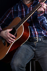 Obraz premium Musiker zieht Gitarre hoch, spielt