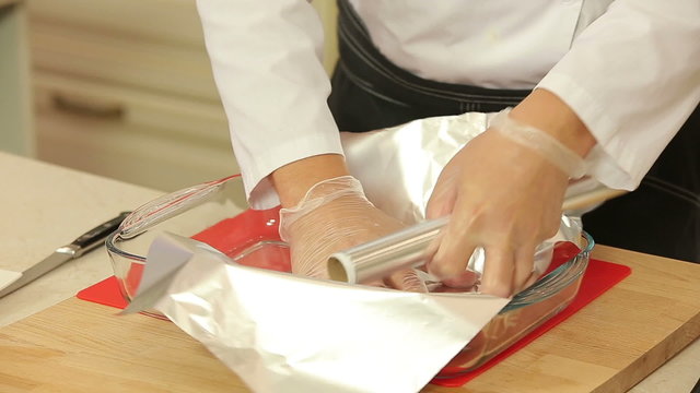 Chef is seasoning fish fillet to bake in foil