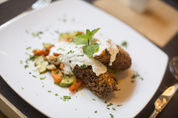 Grilled meat with sauce and herbs served at restaurant