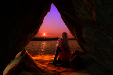 Dziewczyna, blondynka w jaskini o zachodzie słońca.